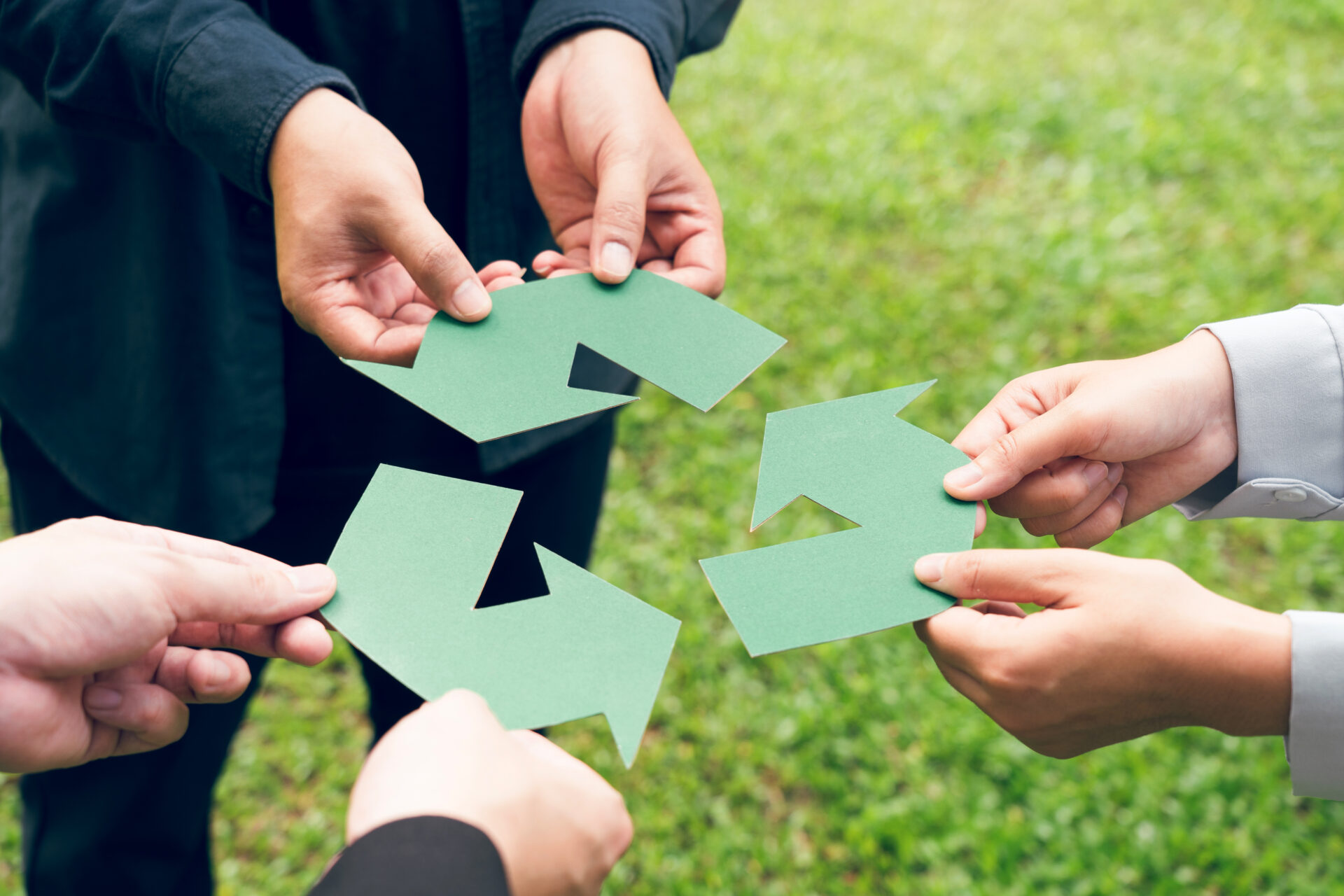 people holding the recycling symbol
