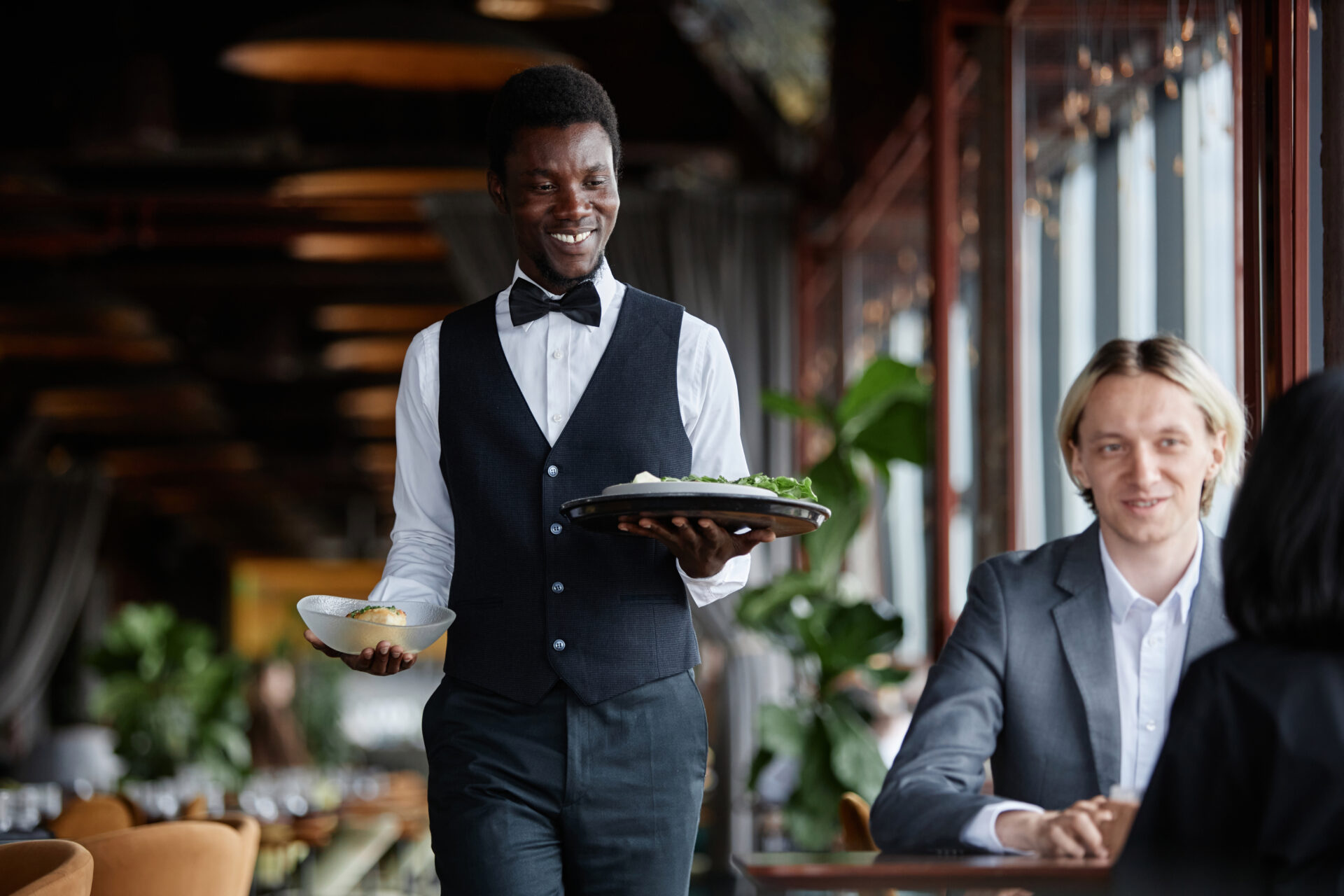 waiter bringing food to table